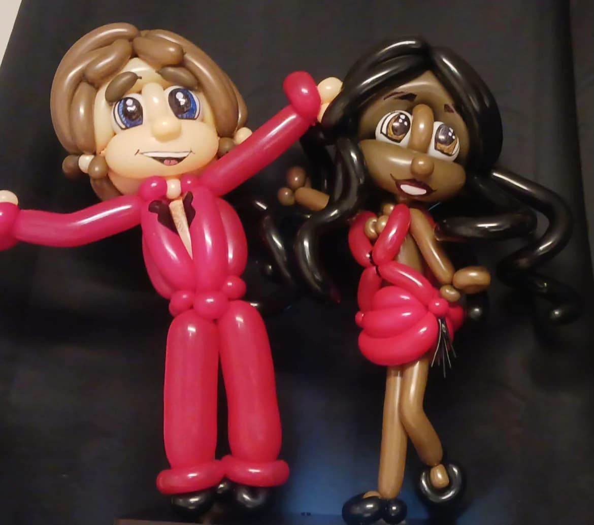 Two personalized balloon caricatures dressed in red