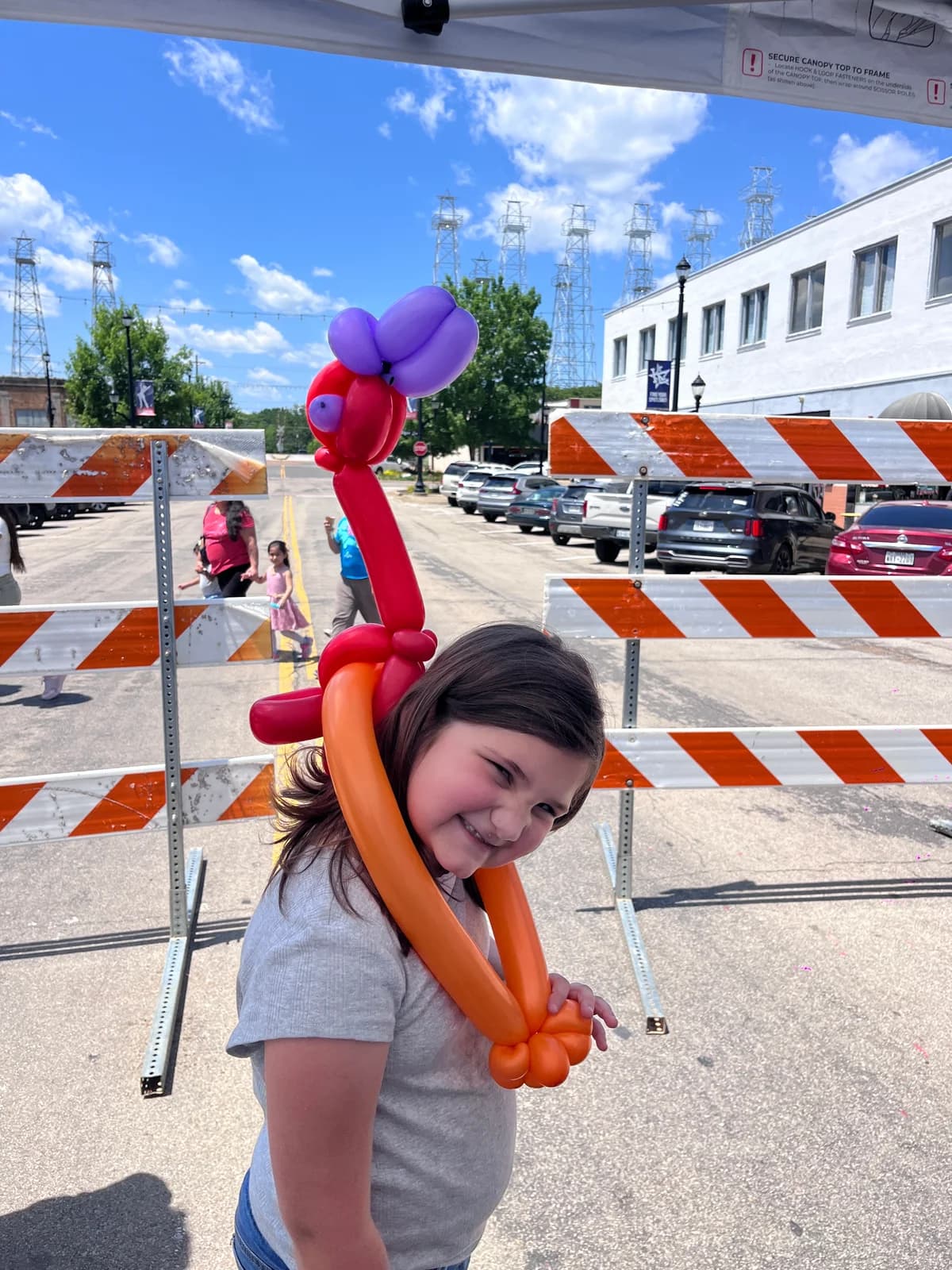 Event guest wearing a tall colorful balloon flower hat