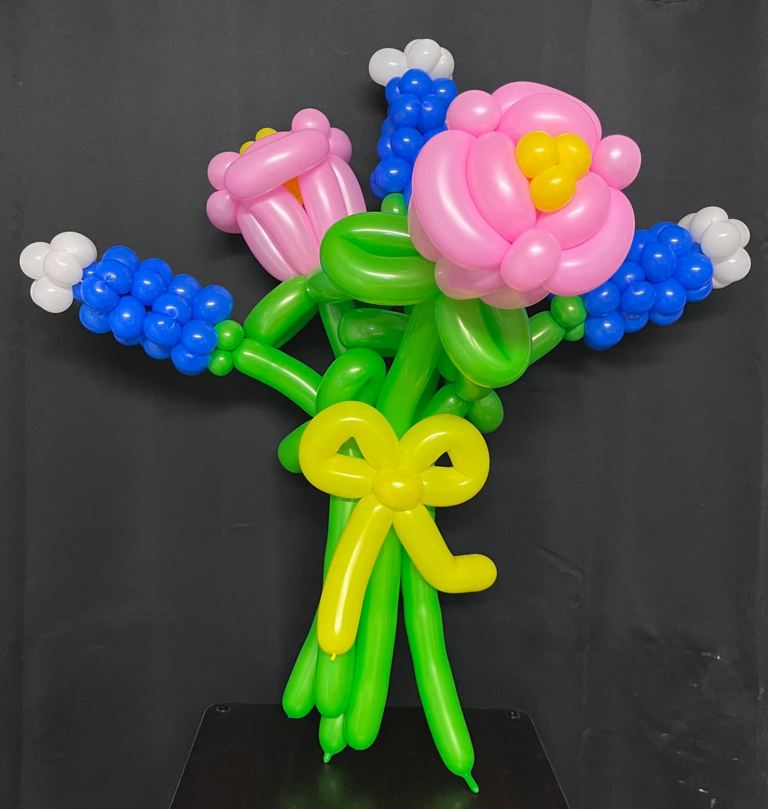 Pink and blue balloon flowers tied with a yellow bow