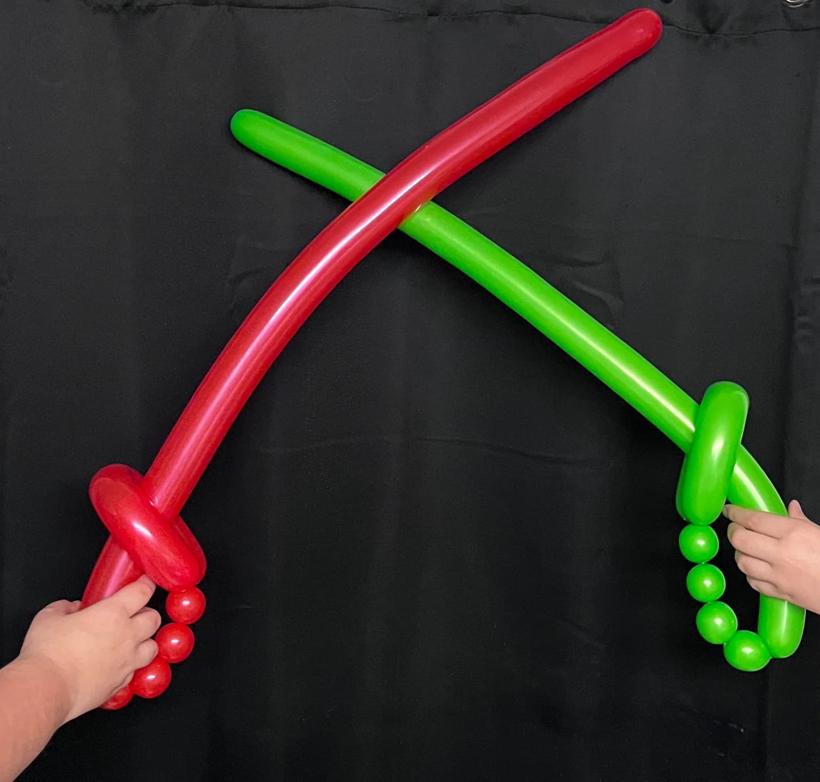 Red and green balloon swords